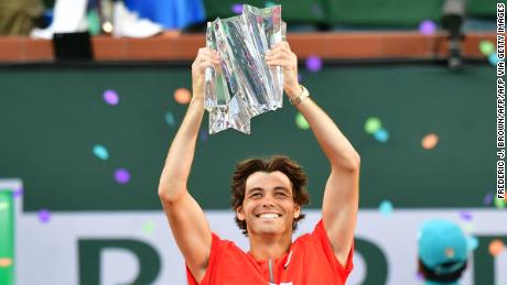 Taylor Fritz hoists the Indian Wells championship trophy after defeating Rafael Nadal.