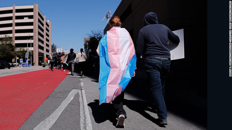 Dylan Yeary (izquierda) usa la bandera trans durante una manifestación por los derechos de las personas trans que marchó por las calles de Austin, Texas, en febrero.
