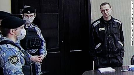 Russian opposition leader and activist Alexei Navalny (right) is seen on a screen during an off-court hearing in the Pokrov penal colony in the Vladimir region of Russia on March 22.