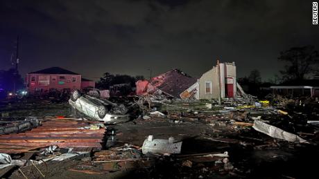 A car lies overturned among debris in the Arabi neighborhood after a large tornado struck near New Orleans Tuesday. 