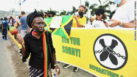 Les gens demandent des réparations pour l'esclavage devant l'entrée du haut-commissaire britannique à Kingston, en Jamaïque, mardi. 