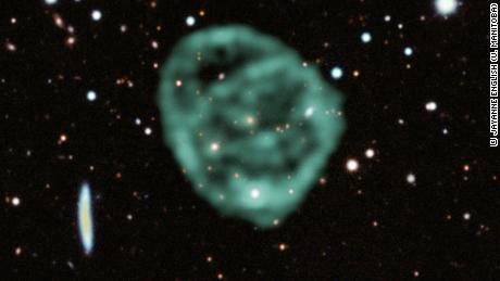 Data from the MeerKAT telescope (green) showing the odd radio circles is overlaid on optical and near-infrared data from the Dark Energy Survey.