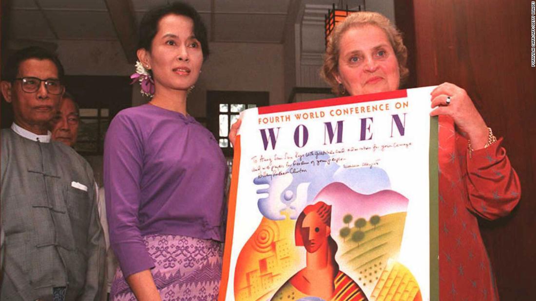 Albright presents a poster from the World Conference on Women as she meets with Myanmar political leader Aung San Suu Kyi in 1995.