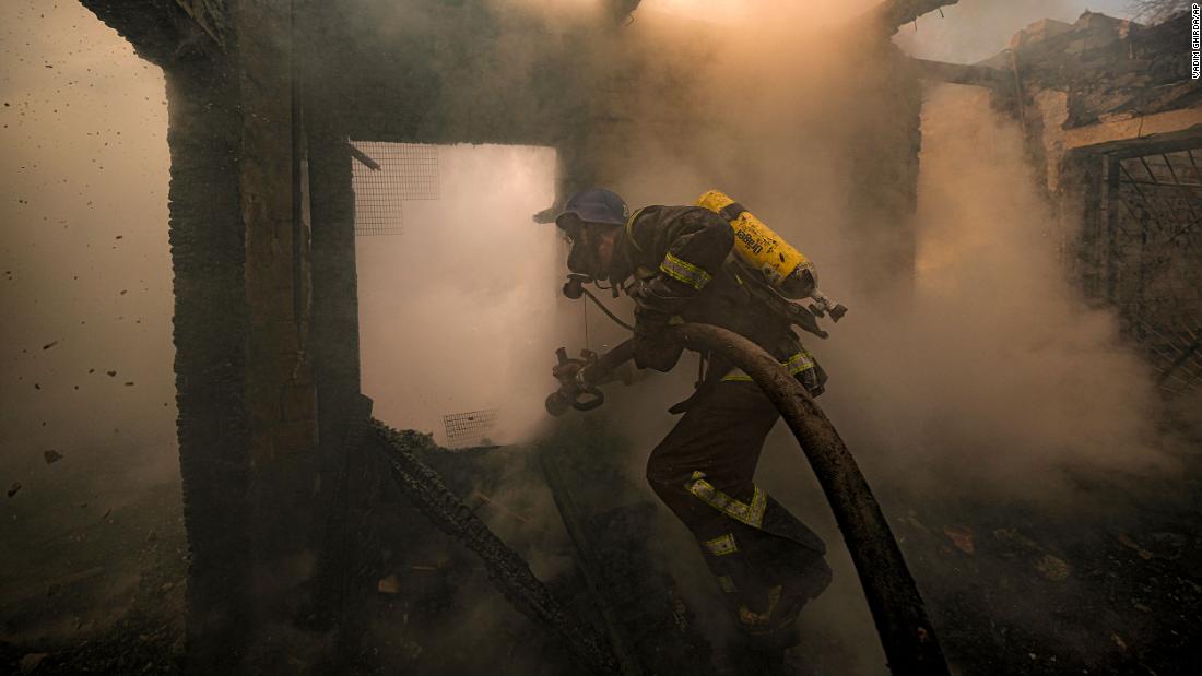 A firefighter sprays water inside a house that was destroyed by shelling in Kyiv on Wednesday, March 23.