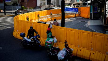 A Delivery Worker Delivers Food To A Woman At The Barriers Of An Area Under Lockdown In Shanghai On March 23, 2022. 