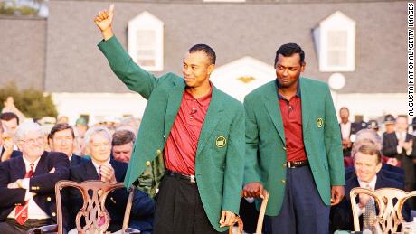 Tiger Woods waves as Vijay Singh looks on during the presentation ceremony of the 2001 Masters tournament.