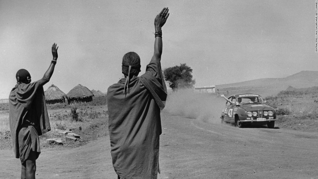 Competitors&lt;strong&gt; &lt;/strong&gt;Pat Moss-Carlsson and Elizabeth Nystrom exchange a wave with Maasai onlookers during practice for the 1966 East African Safari Rally.