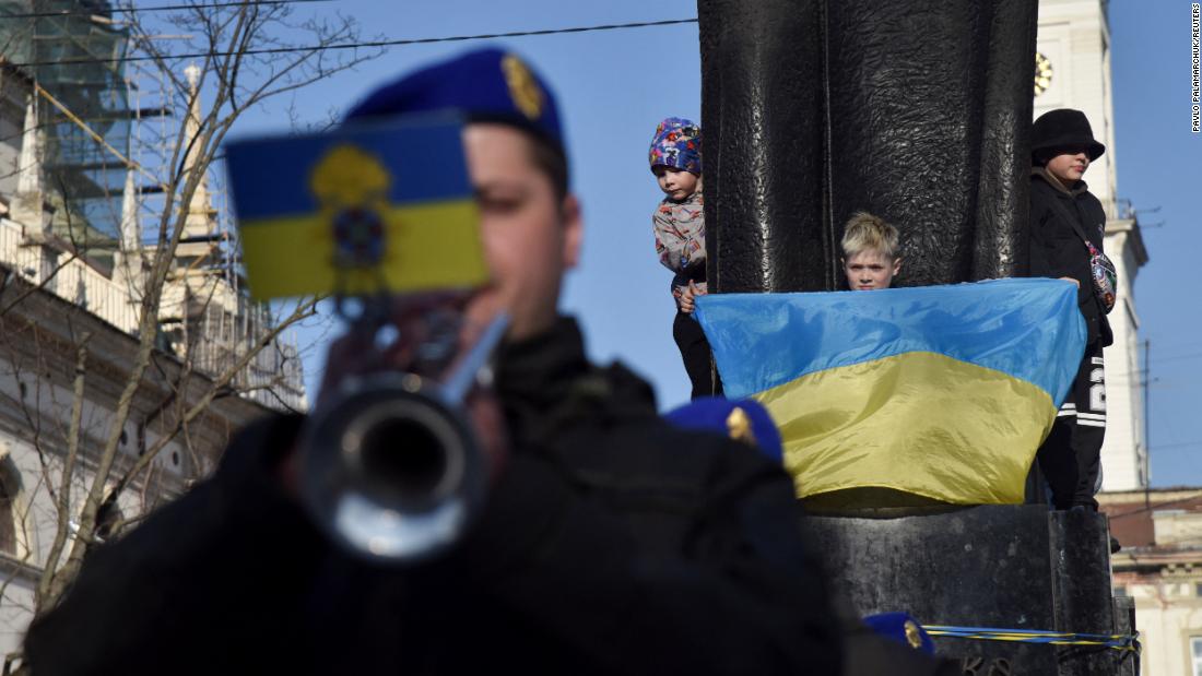 A child holds a Ukrainian flag in front of the Taras Shevchenko monument as members of the Ukrainian National Guard band perform in Lviv on March 24.