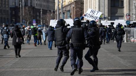 Police officers detain a man holding a placard reading &quot;No to war&quot; during a demonstration against Russian military action in Ukraine, in Manezhnaya Square, central Moscow on March 13.