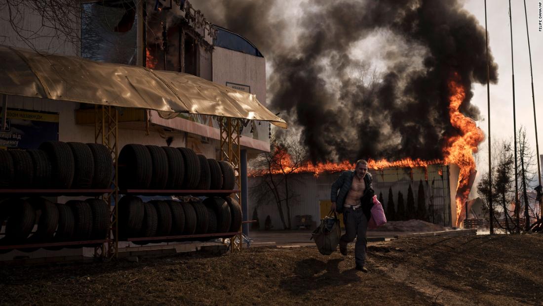 A man recovers items from a burning shop following a Russian attack in Kharkiv on March 25.