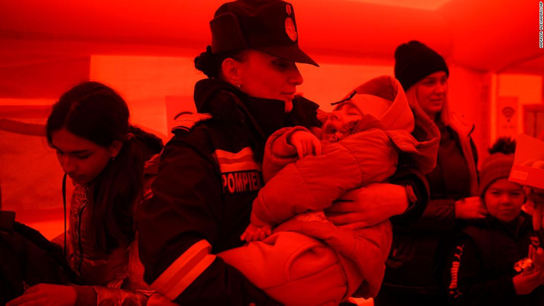 A firefighter holds a Ukrainian child who had just arrived by ferry at the Isaccea-Orlivka border crossing in Romania on March 25.