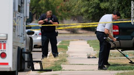 In this August 28, 2015, photo, members of the Bexar County Sheriff's Department investigate the scene where Gilbert Flores was fatally shot.