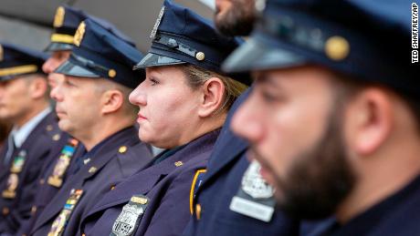 A female police officer stands with her male police department colleagues in New York City.