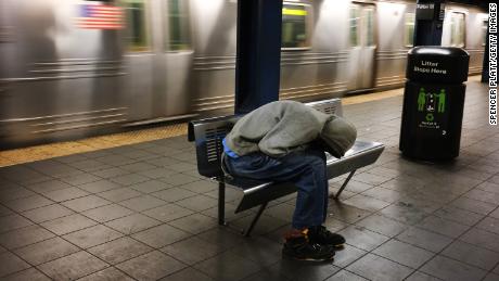 A homeless man sleeps in an empty station as workers close down the New York City subway system, the largest public transportation system in the nation.