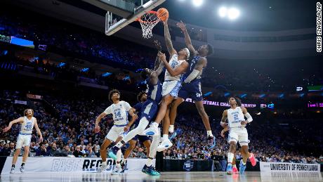 North Carolina&#39;s Armando Bacot goes for a dunk between St. Peter&#39;s Fousseyni Drame, left, and KC Ndefo.