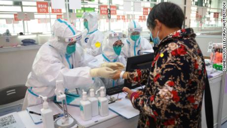 Mitarbeiter helfen am 26. März bei der Registrierung eines Patienten in einer ausgewiesenen Quarantäneeinrichtung in Shanghai.