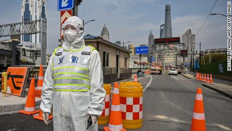 A transit officer, wearing a protective gear, controls access to a tunnel in the direction of Pudong district in lockdown as a measure against the Covid-19 coronavirus, in Shanghai on March 28, 2022. - Millions of people in China&#39;s financial hub were confined to their homes on March 28 as the eastern half of Shanghai went into lockdown to curb the nation&#39;s biggest Covid outbreak. 