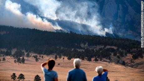 From left to right, Laura Tyson, Tod Smith and Rebecca Caldwell, residents of Eldorado Springs, watch as the NCAR Fire burns Saturday in Boulder, Colorado. 
