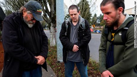 Carl Rhymes, Enoch Gerber and Mike Wade pray for the victims of a car crash that left four people dead Sunday at a homeless camp in Salem.