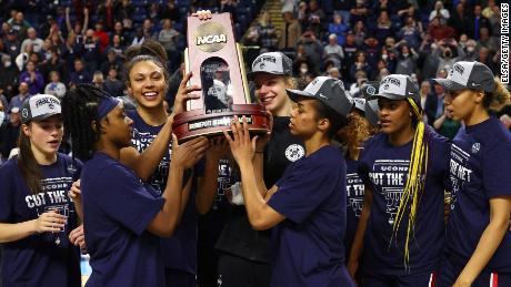 The UConn Huskies pose for photos with the regional championship trophy after defeating North Carolina State 91-87 in double overtime in the Elite Eight in Bridgeport, Connecticut.