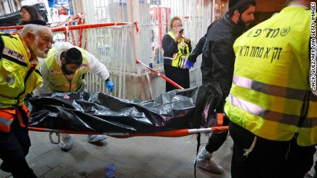 イスラエルの救急隊は火曜日のブネイブラクでの攻撃現場から犠牲者の遺体を取り除きます。