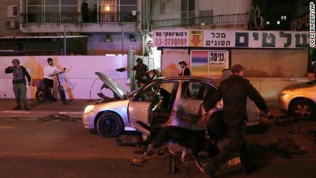 Israeli police search a car at the scene of a shooting in Bnei Brak on Tuesday.