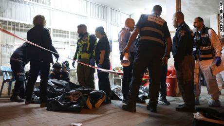 Israeli police and paramedics gather near bodies of people killed by a gunman in Bnei Brak, Israel on Tuesday.