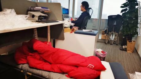 A camping bed set up under at an employee&#39;s desk at a company in Shanghai.