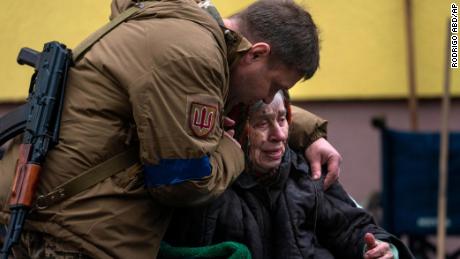 A soldier comforts Larysa Kolesnyk, 82, after being evacuated from Irpin, on the outskirts of kyiv, Ukraine, Wednesday, March 30, 2022.
