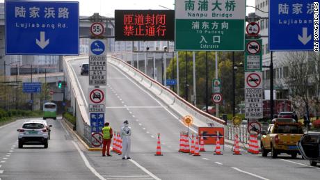 A police officer keeps watch next to a bridge leading to the Pudong area of Shanghai, now in a Covid-19 lockdown.  