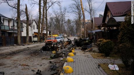 A destroyed Russian armored personnel carrier blocks part of a road in Irpin.