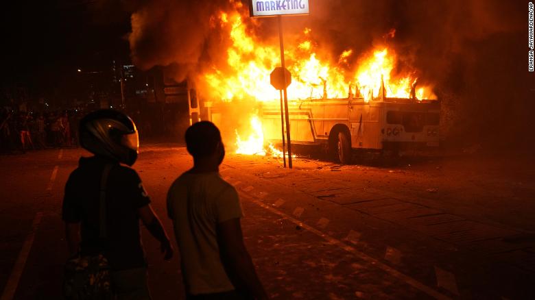 Sri Lankans watch a burning bus during a protest outside the President's home in Colombo on April 1.