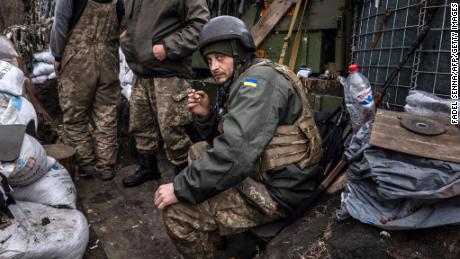 A Ukrainian serviceman smokes a cigarette in a trench at the front line east of Kharkiv on March 31, 2022.