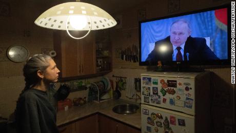 A woman watches Putin speaking during a TV broadcast of a meeting of the National Security Council on the recognition of the self-proclaimed Donetsk People & # 39; s Republic and the Luhansk People & # 39; s Republic on February 21, 2022. 