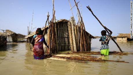 South Sudanese refugees try to repair their hut during the country&#39;s floods in 2021.