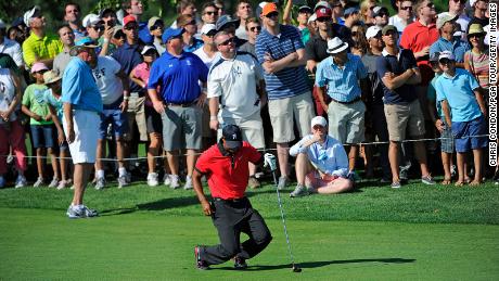 Woods falls to the ground in pain after hitting his second shot on the 13th hole during the final round of The Barclays at Liberty National Golf Club on August 25, 2013.