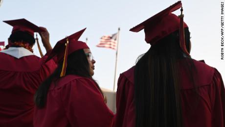 A US flag flies above a building as students earning degrees at Pasadena City College participate in the graduation ceremony, June 14, 2019, in Pasadena, California. - With 45 million borrowers owing $1.5 trillion, the student debt crisis in the United States has exploded in recent years and has become a key electoral issue in the run-up to the 2020 presidential elections.
&quot;Somebody who graduates from a public university this year is expected to have over $35,000 in student loan debt on average,&quot; said Cody Hounanian, program director of Student Debt Crisis, a California NGO that assists students and is fighting for reforms. 