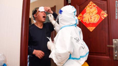 A medical worker carries out door-to-door testing in Changchun on April 5.