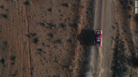 A classic rally car races across the Kenyan landscape
