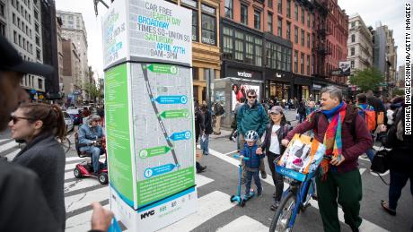 Pedestrians pass a map of street closures on Broadway during Car Free Earth Day in New York City on April 27, 2019. 