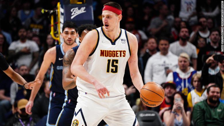 Jokic, sporting a red headband, posts up defenders.