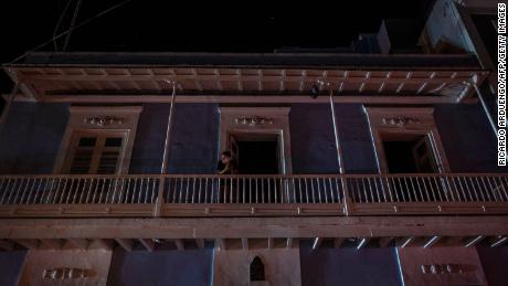 A man stands on a balcony in San Juan after a major power outage on April 6, 2022.