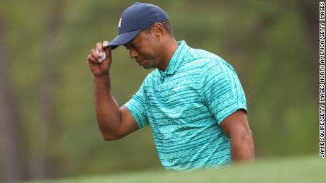 Woods takes his hat off after making a bogey on the 12th green.