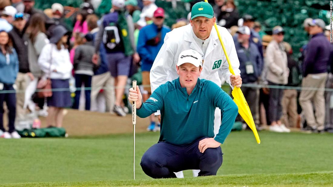 Robert MacIntyre lines up a putt with help from caddie Michael Thomson on Saturday.