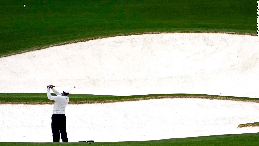 Woods plays a shot from a bunker on the eighth hole Saturday.
