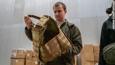A Ukrainian civil defender holding a vest that was provided by the Ukrainian American Coordinating Council after one of the shipments of donations arrived in Ukraine.