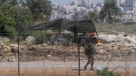 An Israeli soldier guards an opening in Israel's West Bank separation barrier on April 10.
