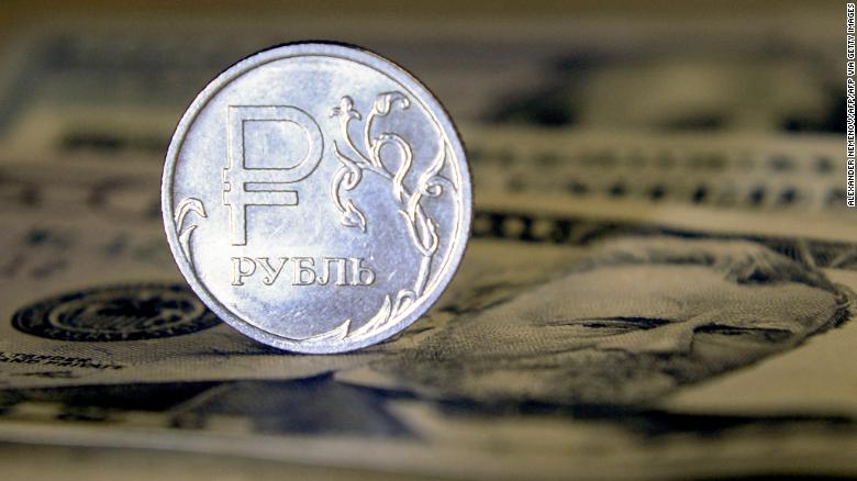 A Russian ruble coin is pictured with US dollar bills in Moscow, on August 23, 2018. - Russia's ruble hit its lowest level against the dollar for more than two years, a day after the latest round of punitive US sanctions took effect. The ruble's value dropped to 69 against the dollar for the first time since April 2016, when the shocks from the first Western sanctions over Russia's actions in Ukraine were still being felt. (Photo by Alexander NEMENOV / AFP) (Photo by ALEXANDER NEMENOV/AFP via Getty Images)