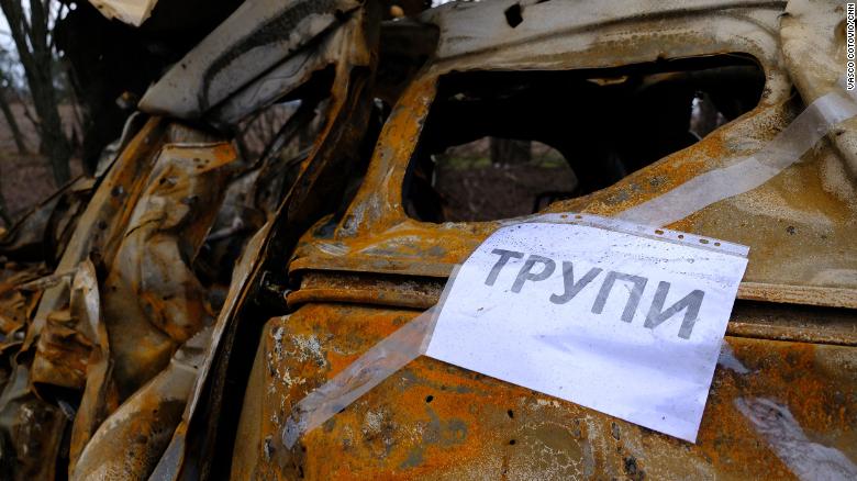贴在一辆烧毁的汽车上的牌子上写着“尸体”;用乌克兰语告诉搜索队在哪里寻找尸体。