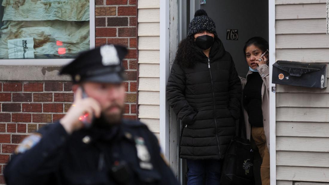 People look out of a home near the scene of the shooting.